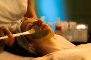 a man laying on a bed brushing his teeth at Villa Nicolli Romantic Spa Resort - Adults Only in Riva del Garda