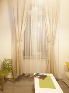 a room with a table and a window with curtains at Apartamenty Winnicy Kresy II in Krakow