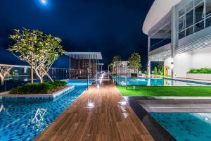 ゲンティンハイランドにあるGenting Windmill Moutain view 4-ROOM Executive Suiteの夜間のスイミングプールの景色を望む建物 +20枚の写真