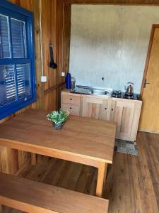 einen Holztisch in einer Küche mit einer Theke in der Unterkunft CASA DE CAMPO FAZENDA DAS PELOTAS in Bom Jardim da Serra