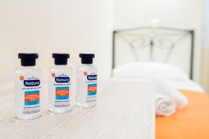 three bottles of medicine sitting on a table next to a bed at Athens Psiri Hotel in Athens