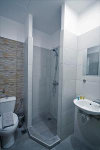 a bathroom with a shower and a toilet and a sink at Athens Psiri Hotel in Athens