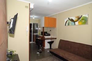 sala de estar con sofá y cocina en Apart Hotel Temuco, en Temuco