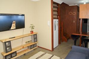 a living room with a tv on a wall at Apart Hotel Temuco in Temuco