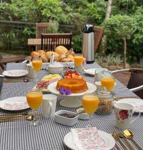 a table with food and glasses of orange juice at Solar 197 Pousada in Timbó
