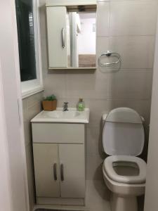 un bagno con un water, un lavandino e uno specchio di Ap 304 - Beira mar - pés na areia a Capão da Canoa Altre 9 foto