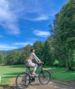 a woman riding a bike down a dirt road at Handara Golf & Resort Bali in Bedugul