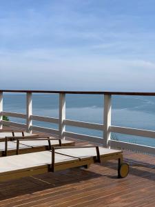 three benches on a deck with the ocean in the background at Villa Dei Fiori in São Sebastião
