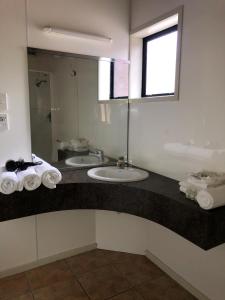 Baño con 2 lavabos y espejo en Wylie Court Motor Lodge en Rotorua