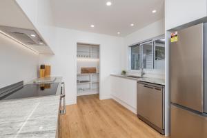 a kitchen with white walls and stainless steel appliances at Waterfront Beach House - Paihia Holiday Home in Paihia