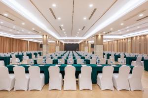 a large banquet hall with tables and white chairs at Holiday Inn Chongqing University Town by IHG in Chongqing +69 photos