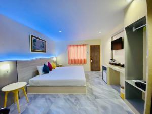 een slaapkamer met een bed en een tafel in een kamer bij Aochalong Villa Resort & Spa - SHA Plus in Chalong 