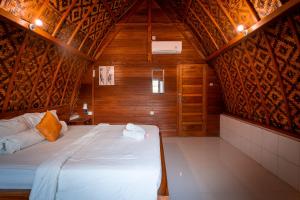 - une chambre avec un lit dans une pièce en bois dans l'établissement Penida Krusty Hill by ecommerceloka, à Nusa Penida