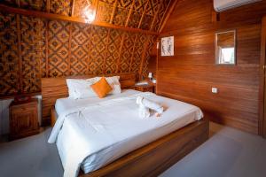 - une chambre avec un grand lit et des murs en bois dans l'établissement Penida Krusty Hill by ecommerceloka, à Nusa Penida