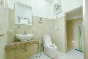 un bagno con lavandino, water e specchio di Andarawewa Nature Resort a Anuradhapura