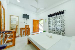 a bedroom with a bed and a desk and a television at Andarawewa Nature Resort in Anuradhapura