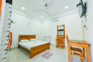 a bedroom with a bed and a desk in a room at Andarawewa Nature Resort in Anuradhapura