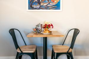 a table with two chairs and a plate of food on it at The Apartment - Sea Views at Te Whau Point by Waiheke Unlimited in Omiha