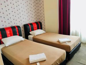 um quarto com duas camas com toalhas em Hotel Bestari em Malaca