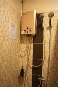 a shower in a bathroom with a machine on the wall at Bann Suan Maya in Mae Rim