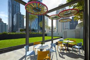 a patio with tables and chairs and umbrellas at lyf Sukhumvit 8 Bangkok Managed by The Ascott Limited in Bangkok