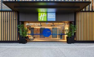 Holiday Inn Express Sydney Airport, an IHG Hotel في سيدني: امامه متجر به اثنين من النباتات الفخارية