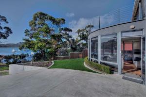 uma casa de vidro com vista para a água em Rest Point em Coles Bay