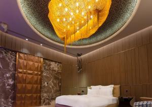 a room with a bed and a ceiling with a chandelier at Royal Group Motel Jhong Hua Branch in Kaohsiung