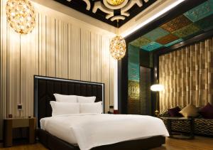 a bedroom with a large white bed and a couch at Royal Group Motel Jhong Hua Branch in Kaohsiung