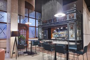 a bar with tables and chairs in a room at Silken Ramblas in Barcelona