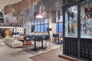 a lobby with a bar and some chairs and tables at Silken Ramblas in Barcelona