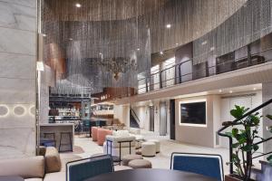 a lobby of a hotel with tables and chairs at Silken Ramblas in Barcelona