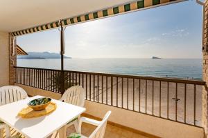 a balcony with a table and chairs and a view of the ocean at Apartamentos María Cristina Beach in Benidorm