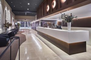 a lobby with a long counter with flowers on it at Silken Ramblas in Barcelona