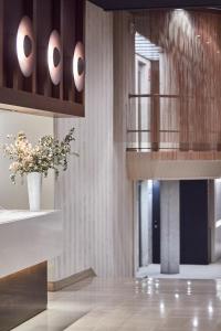 a lobby with a vase of flowers and a staircase at Silken Ramblas in Barcelona