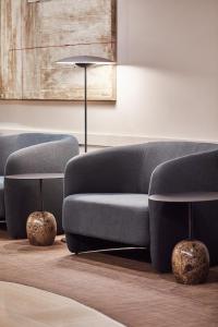 a living room with a couch and two chairs at Silken Ramblas in Barcelona