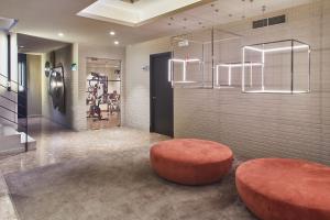 a room with a red stool and aception at Silken Ramblas in Barcelona