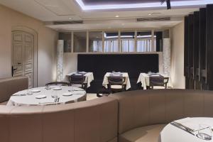 a restaurant with tables and chairs and a projection screen at Silken Ramblas in Barcelona