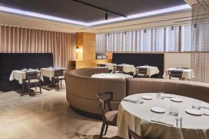 a restaurant with white tables and chairs and a round room at Silken Ramblas in Barcelona