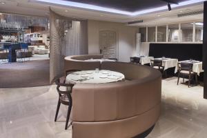 a restaurant with a round table and chairs in a room at Silken Ramblas in Barcelona