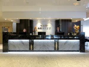 a lobby with two people sitting at a reception desk at Nash Airport Hotel in Geneva