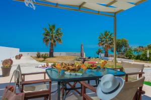 a table on a patio with a view of the beach at Gaia Beach House in Alikanas