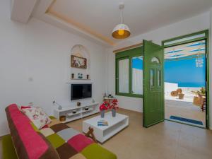 a living room with a couch and a green door at Gaia Beach House in Alikanas