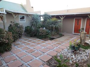 a stone walkway in front of a house at Masada Guest House in Langebaan