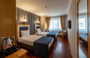 una camera d'albergo con due letti e una sedia di Nova Plaza Taksim Square a Istanbul
