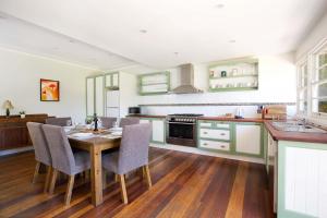 una cocina con mesa de madera y sillas. en Rodova Cottage, en Katoomba 4 fotos más