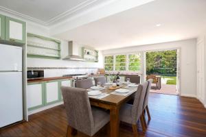 a kitchen and dining room with a table and chairs at Rodova Cottage in Katoomba