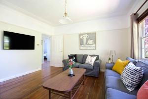 a living room with a couch and a table at Rodova Cottage in Katoomba