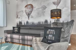 a living room with a couch and a wall with hot air balloons at The Cloud Suite Apartments in Freiburg im Breisgau