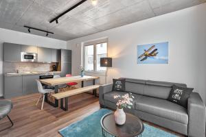 a living room with a couch and a table at The Cloud Suite Apartments in Freiburg im Breisgau
